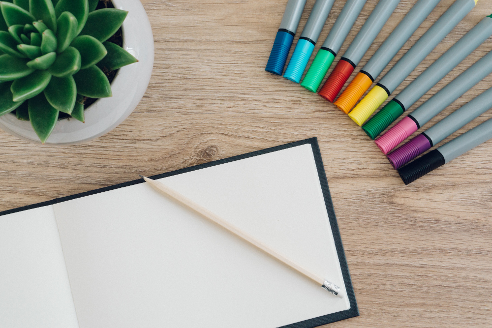 Мінімальний набір для скетчингу: блокнот, олівець та акварельні маркери на дерев’яному столі